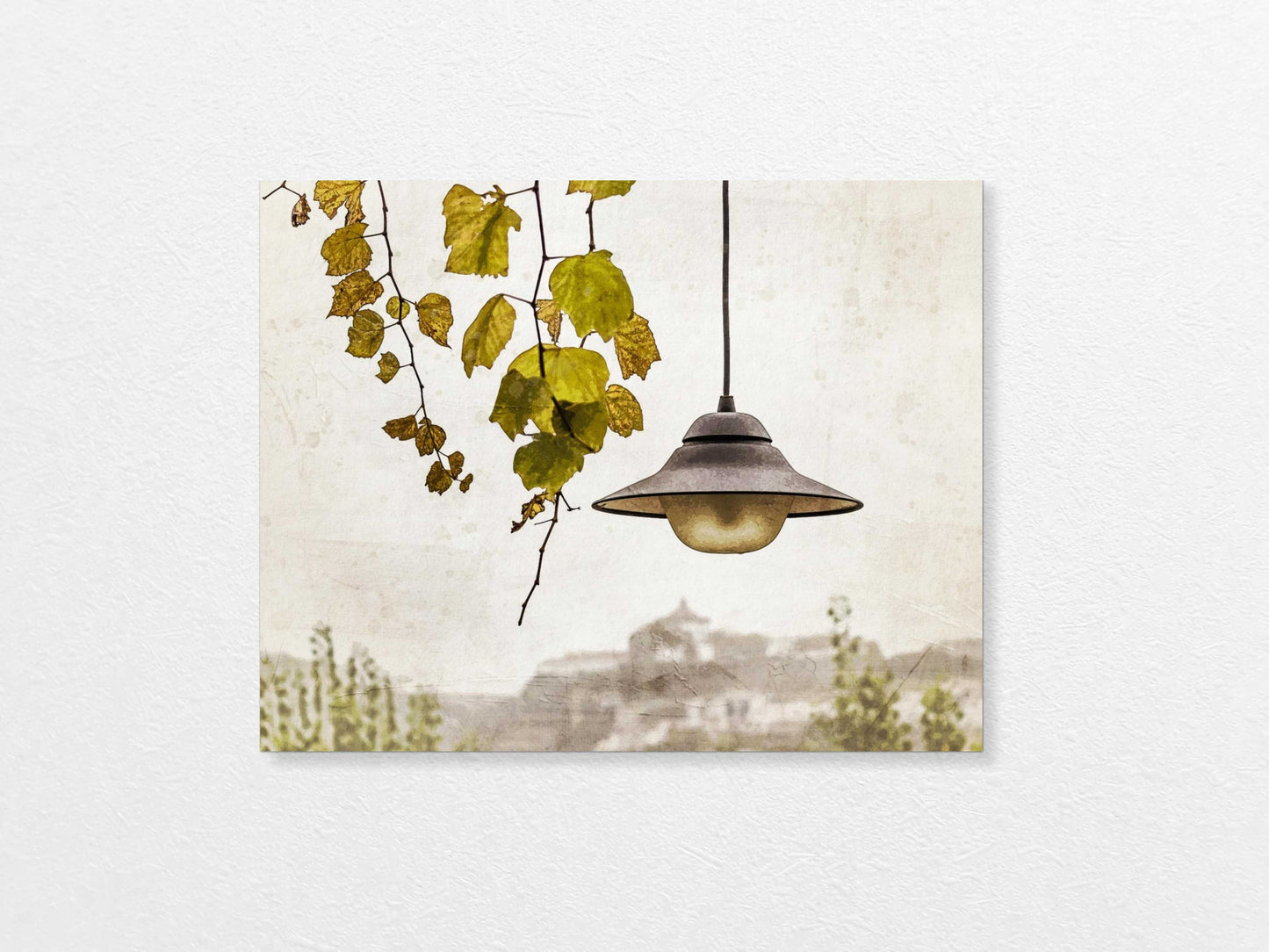 Light bulb hanging above with a view of Porto  in the background, featuring trees and buildings.
