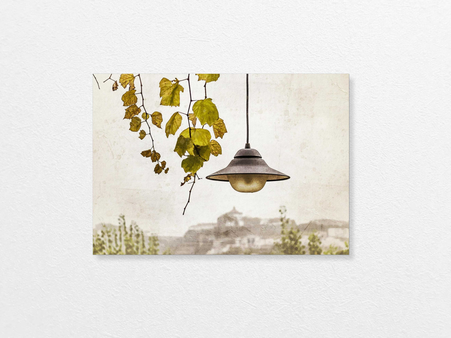Light bulb hanging above with a view of Porto  in the background, featuring trees and buildings.